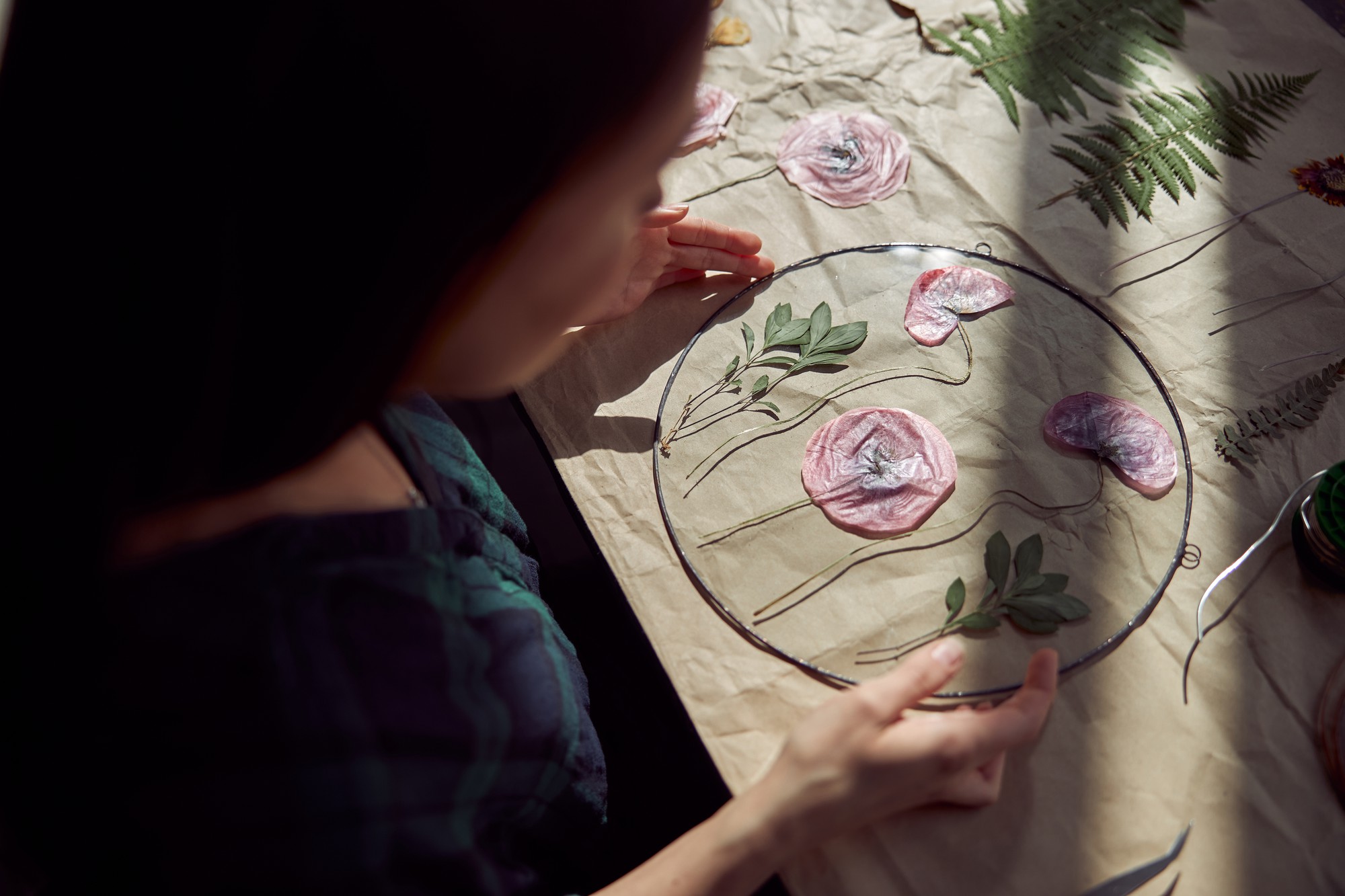 Workshop hands embroidering a floral patch
